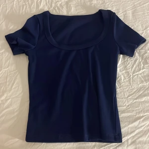 Topp/t-shirt💙 - Säljer en snygg ribbad topp/t-shirt från SHEIN. Den är marinblå. Den formar sig tajt på kroppen och får fram kurvor men den är fortfarande skön och stretchig. Den är i storlek S men kan passa folk med storlek M eftersom den är så strechig.