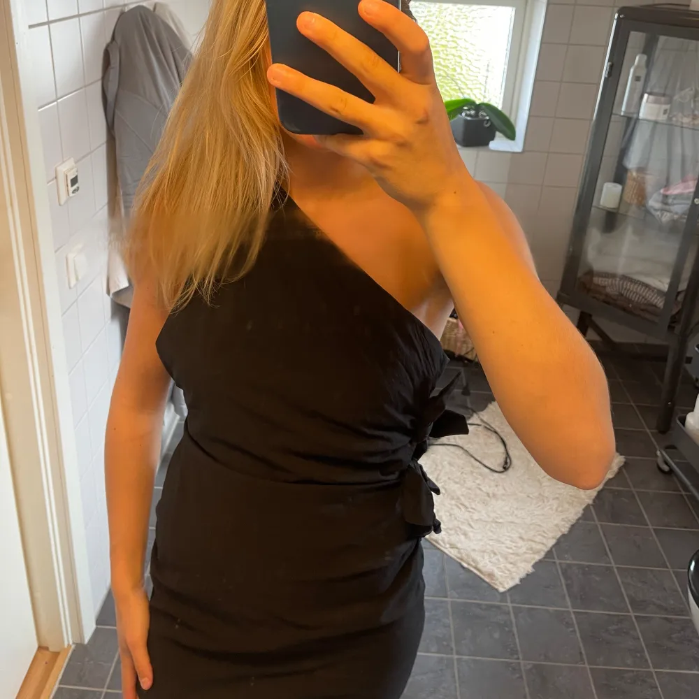 Superfin svart rosettklänning ifrån zara💕 oneshoulder med rosetter längst ena långsidan och på ena axeln😁 helt slutsåld och endast använd en gång. Storlek M men passar även mig som är en S/xs. Klänningar.