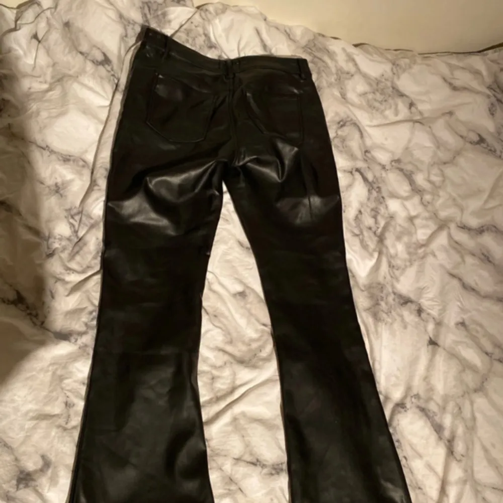 Bootcut byxor i skinn imitation från Gina tricot, mid/low waist, storlek 42, använda fåtal gånger. Jeans & Byxor.