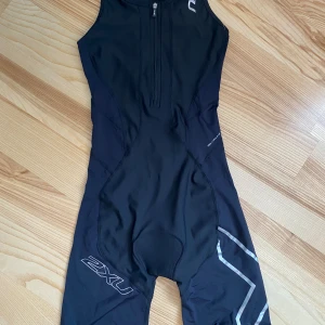 Trisuit 2XU, strl S, NY - Aldrig använd.  Katt finns i hemmet (allergivänlig ras). Jag är väldigt mån om mina köpare så om du skulle vara missnöjd med ditt köp kontakta mig innan dåligt omdöme. Så har jag en chans att rätta till det!