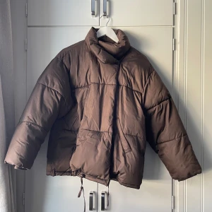 Pufferjacket - Brun pufferjacket från Nakd. Använd cirka 5 ggr så i väldigt fint skick! Storlek 34!
