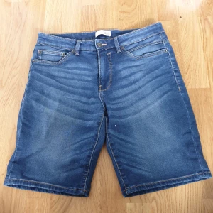 Blå jeansshorts från Solid - Säljer ett par snygga blå jeansshorts från märket Solid. De är i storlek M och har en regular fit passform. Shortsen har klassisk design med fem fickor och dragkedja. Perfekta för sommaren! skick: bra skick, dem har befunnit sig i samma hem som en katt 