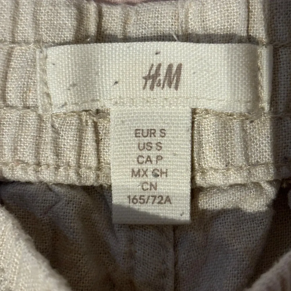 Säljer ett par bekväma beige shorts från H&M i storlek S. De är gjorda av linne och har en elastisk midja för extra komfort. Perfekta för sommaren!. Shorts.