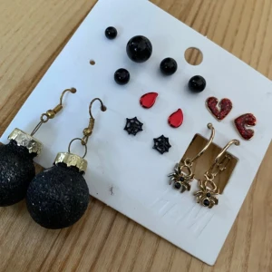 Örhängen HALLOWEEN jul m.m - Säljer ett set med flera olika örhängen.  Innehåller svarta, röda, guldiga örhängen i olika former som hjärtan, bloddroppar, spindlar, spindelnät samt ett par stora svarta julkulor, och bjällror.  Begagnat skick och defekter finns, därav lågt pris!