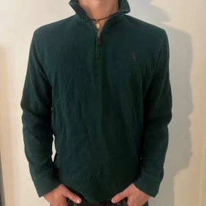 Mörkgrön Ralph Lauren Halfzip - Säljer en snygg mörkgrön tröja från Ralph Lauren. Den har en halv dragkedja framtill och en liten broderad logga på bröstet. Storlek M. Modellen är 182 cm och väger 75 kg. Pris går att diskuteras!