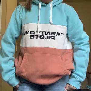 En mysig, fin och äkta twenty one pilots hoodie ifrån bandets egna merch sida! Storlek M och aldrig använd förut. 🩵🤍🧡