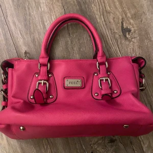 Rosa väska  - Säljer denna skiiiittt snygga och vintage aktiga väska, har ej fått någon användning av den och de är darför jag säljer den. Den är helt som ny! Pris kan diskuteras !🥰