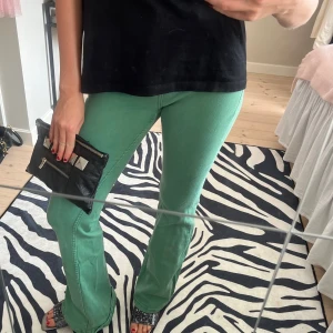Gröna byxor - Ett par gröna byxor med bootcut. Byxorna har en normal passform och är högmidjade.
