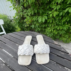 Vita sandaler med flätad design - Säljer ett par vita sandaler med en snygg flätad design😍. Perfekta för sommaren! De är i välanvänt skick med lite slitage på sulan. varav priset!🥰
