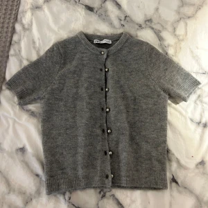 Stickad t-shirt - Stickad t-shirt från zara med silverknappar❤️ Används inte längre tyvärr. Den har ett litet hål i en av armhålorna, men det syns inte när man har på sig tröjan. I övrigt så är den i bra skick❤️ Skriv priv vid frågor