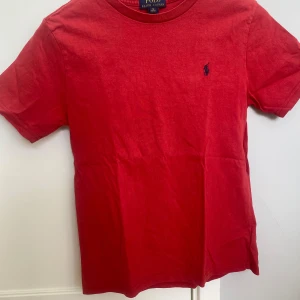 Ralph lauren T-Shirt - Tja! Säljer denna röda feta Ralph lauren t-shirt i storlek M/10-12år (passar även 13) Skicket är 9,5/10 den är lite solblekt. Priset är 109 Kr. Skriv gärna om ni har några frågor eller funderingar.