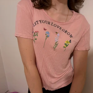 rosa T-shirt  - en tunn sommar T-shirt med blommor. Den kommer strykas inför posten:) Säljer då den inte kommer till användning längre.