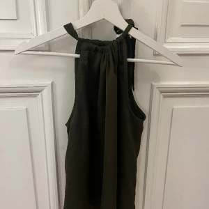 Mörkgrön halterneck topp  - Säljer denna fina mörkgröna halterneck toppen i storlek S. Knappt använd