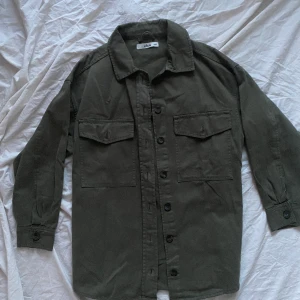 Militärgrön skjorta  - Skjorta från ellos i storlek 38/40. Färgen är militärgrön. Aldrig använd. 