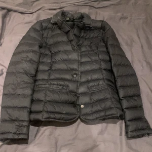 Jacka  - En en svart tunn jacka 