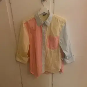 En oversized skjorta i storlek xs från Gina tricot. Den är ljus gul, ljus blå och rosa med vita ränder. Väldigt fint skick. 