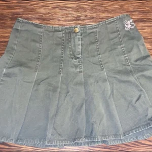 Volangkjol - Olivgrön volangkjol i jeans liknande tyg med ett gulligt rosa tryck på sida