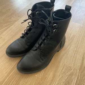 Svart känga  - Svart känga i storlek 40. Snörning framtill samt dragkedja på insidan av skon. Använda en gång. 