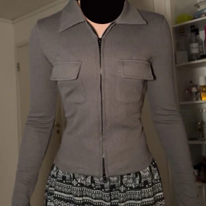 Fin mörk grå zip up tröja - Jätte fin mörk grå zip up tröja med fickor fram. Lite höghalsad, och endast använt en gång.