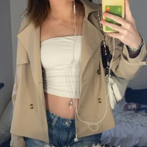 Kort trenchcoat  - Begie trenchcoat passar till allt skit snygg säljer för den är för liten 