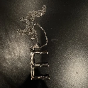 Halsband - Jättefint halsband med bokstaven ”E” säljer då jag börjat använda guldsmycken. Skriv för fler bilder!