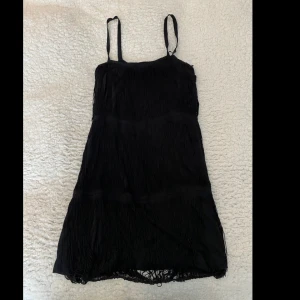 Fin kort klänning med fastsydda tunna snören  - En fin klänning som är både elegant och bekväm att ha på sig! En av axelremmarna har lossnat lite men den sitter ändå bra och det går nog utan problem att sy ihop den lilla biten.