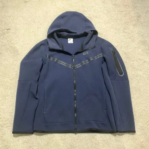 Nike Tech Fleece - Mörkblå Nike Tech Fleece zip-up köpt ny från Nike-appen. Den är använd men i väldigt bra skick och väldigt skön. Det finns också möjlighet att köpa byxorna och tröjan på min profil.