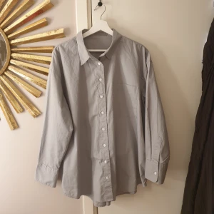 Skjorta  - Ljusgrå skjorta med oversized passform. Använd en gång.