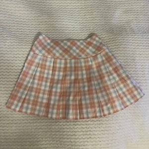 Rosa rutig kjol - Pastell rosa minikjol med veck i strl 36. Aldrig använd!