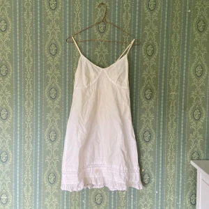 Vit sommarklänning  - Jättefin vintage sommarklänning. Storlek S men insydd där bak för att passa XS. Fläck på nedre kanten som eventuellt går att tvätta bort. 