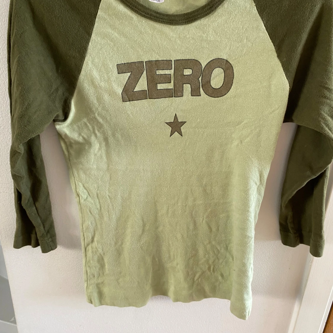 Grön långärmad tröja med texten ZERO