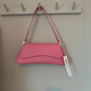 Rosa väska - Denna snygga rosa väskan har inte kommit till användning. Orginal pris 299, oanvänd och prislappen sitter kvar.💘