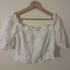 Vit topp - Vit topp med blommigt mönster. Off shoulder. Knappt använd.