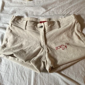Fina loweaist shorts lana del ray shorts - Vita plych shorts med Lana del ray text inbroderad. 