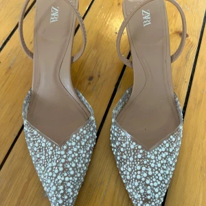 Klackskor stl 36 - Glittriga klackskor i storleks 36 säljes Nypris ca 650kr Används en gång (på bal). Ett märke bak på ena klacken, se bild 2🌸  
