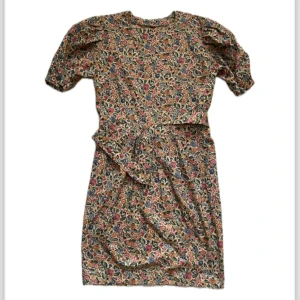 Bomullsklänning 80-tal - Bomullsklänning i blomstermönster med skärp och fickor.