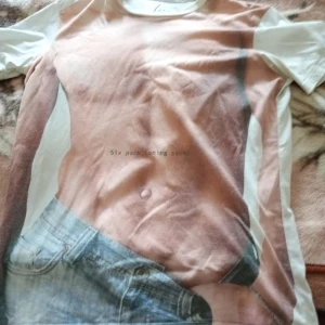 Herr T-shirt med motiv fram stl ,M/L. - T-shirt med motiv fram av en kropp mm stl M/L .slitage finnes o Tillfredsställande .