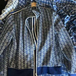 Lacoste dress - Mycket bra skick använd endast 2 gånger, säljs pga nya köp. Kofta storlek M, Byxor storlek L. Byxorna passar för er som är 180 till 190 ungefär.