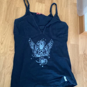 Y2k svart swe street linne - Jättefint linne med vingar och fin form från 00-talet. Ser inte så bra ut på mig för att det inte är min storlek men ser säkert mycket bättre ut på någon annan🩷