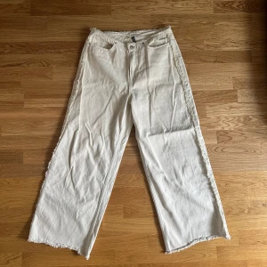 Beige jeans - Beige jeans med coola detaljer på sidorna och i midjan. Använda 2 ggr och tvättade en gång.