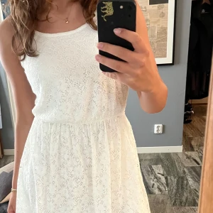 Klänning med broderi anglaise och öppen rygg - Super söt klänning med broderier samt öppen rygg, knä lång och perfekt till somriga dagar och stranden.  