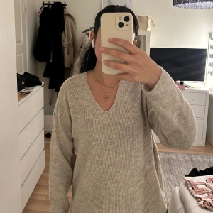 Tjocktröja från Vero Moda.  - Beige/ljusgrå v-ringad tjocktröja. Perfekt skick. Rätt tunnt o skönt material, Kliar inte. Lappen sitter kvar. 