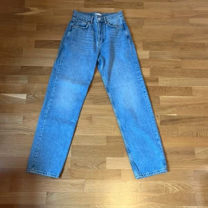 Högmidjade lössittande jeans  - Ett par ljusblå högmidjade jeans i en lössittande modell från Gina tricot. Jeans är oanvända. 