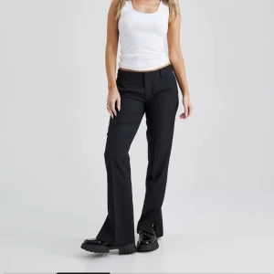 Bikbok Kostymbyxor Vera petite  - Svarta snygga kostymbyxor från bikbok i modellen ”Vera” petite.  Dom är Lågmidjade med slits längst ner☺️ säljer då dom är för korta men har inga defekter! 