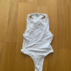 Ohpolly bodysuit - Vit bodysuit från ohpolly Öppen i ryggen, stängs nertill, stretchig Dubbel lager så den är inte see through Stl: 38/M/10