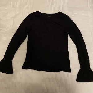 Tunnstickad tröja - Tunnstickad svart blus/tröja med detalj i ärmslut. Storlek XS i gott skick.