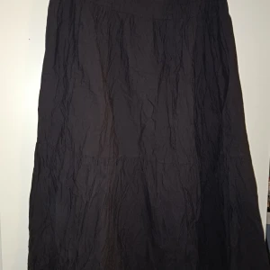 Lång svart volangkjol - Lång svart volangkjol, ca 105cm lång. Ca 80cm i midjan, resår i midjan. Aldrig använd.