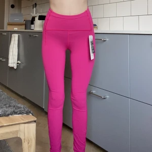 Lululemon träningtajts rosa strl 4 (S) - Ett par oanvända Lululemon träningstajts med lapparna kvar i strl 4 vilket motsvarar ungefär storlek S. Rosa med mobilficka. Köpta i deras butik i Stockholm. Köpta för 1300kr.