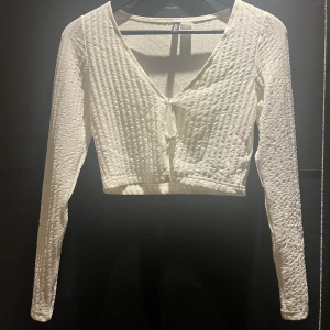 Kofta - Kort vit kofta med två knappar. Mindre svart fläck på bilden.