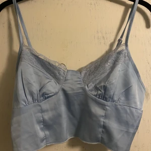 Ljusblått spetslinne i satin - Ljusblått spetslinne i satin. Bra skick. Strl xs